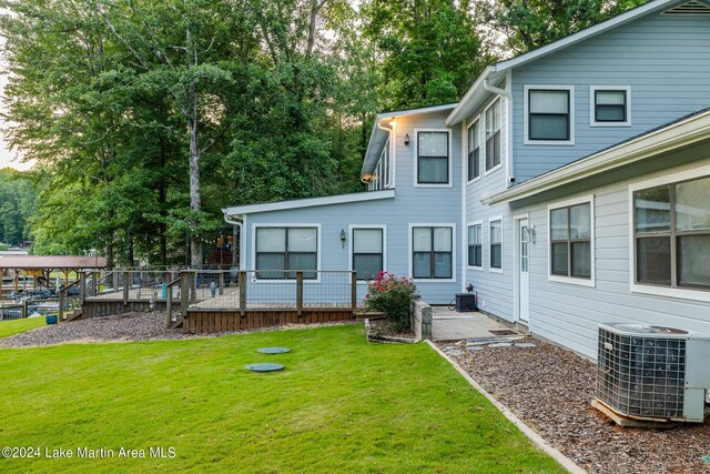 rear view of property featuring central AC and a yard