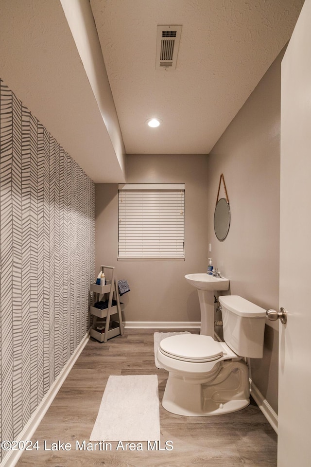 bathroom with wood-type flooring and toilet