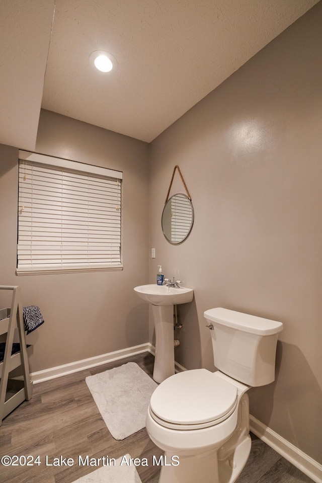 bathroom featuring hardwood / wood-style flooring and toilet