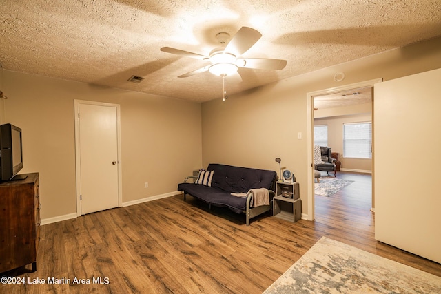 sitting room featuring ceiling fan, hardwood / wood-style floors, and a textured ceiling