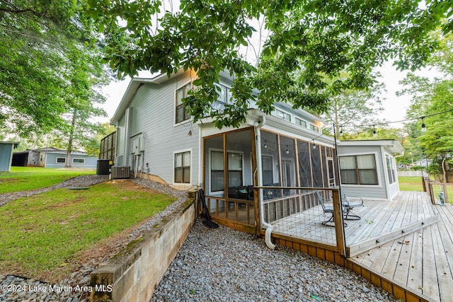 rear view of house with central AC, a sunroom, a yard, and a wooden deck