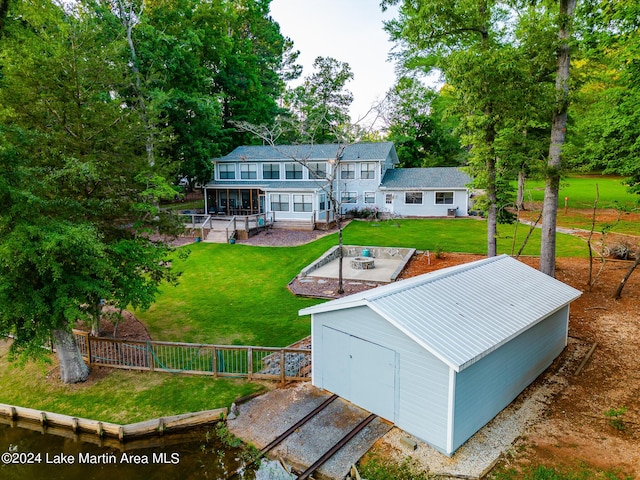 rear view of house featuring a patio area, a yard, an outbuilding, and a garage