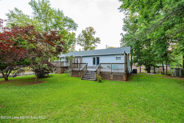 rear view of property featuring a wooden deck, a yard, and central AC unit