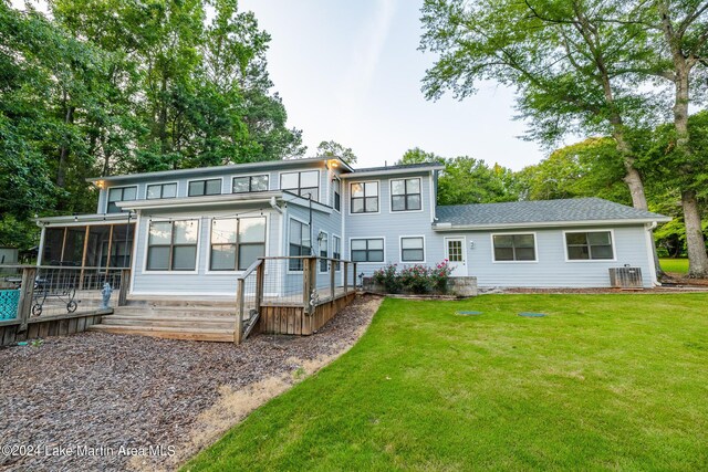 back of property featuring a sunroom, central AC unit, and a yard