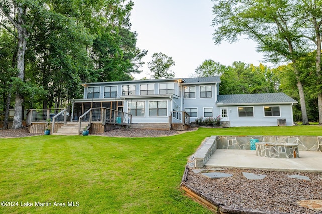 rear view of property with a lawn, a patio area, and a sunroom