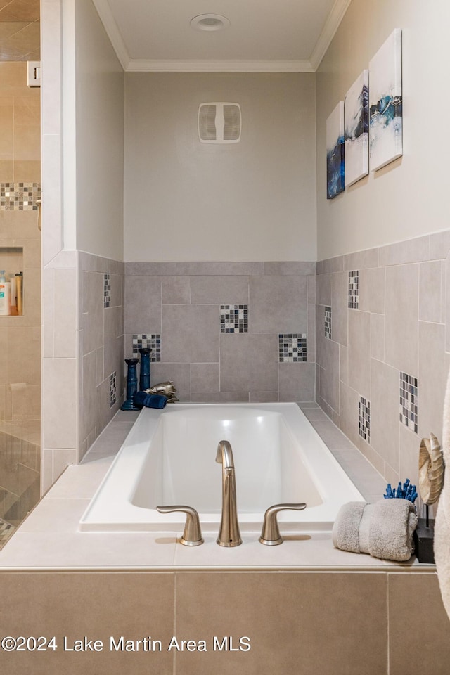 bathroom featuring tiled tub, tile walls, and ornamental molding