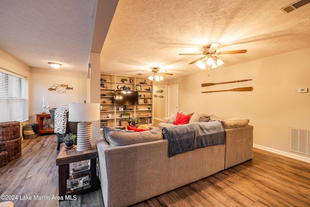 living room featuring ceiling fan, a textured ceiling, and hardwood / wood-style flooring