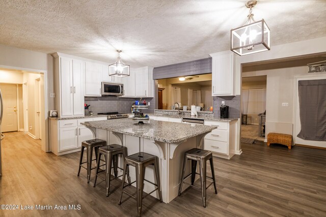 kitchen featuring decorative backsplash, stainless steel appliances, and hanging light fixtures