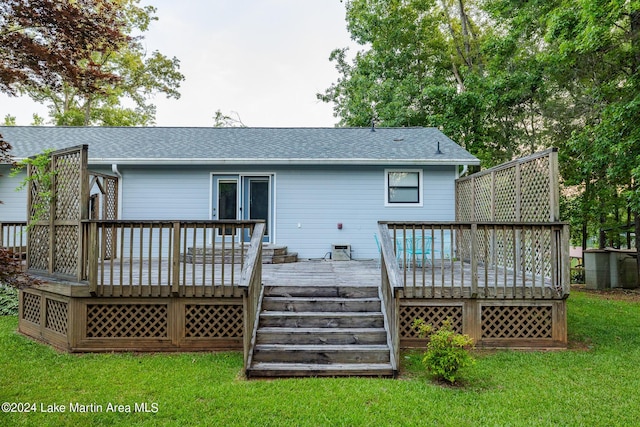 rear view of property featuring a deck and a yard