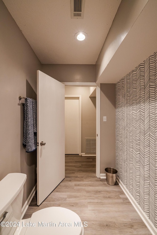 bathroom with hardwood / wood-style floors and toilet