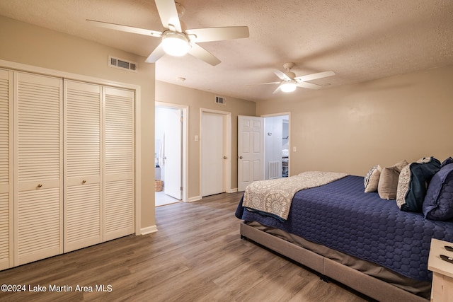 bedroom with hardwood / wood-style floors, ceiling fan, a textured ceiling, and a closet