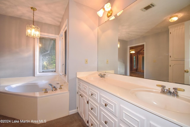 bathroom with vanity, a tub, and a chandelier