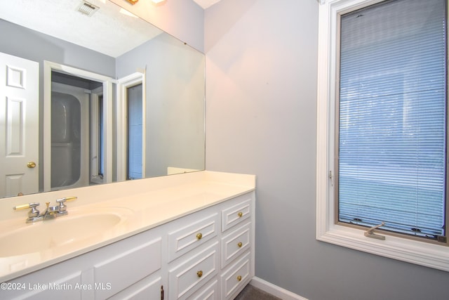 bathroom featuring a textured ceiling and vanity