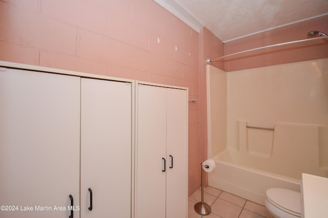 bathroom with tile patterned flooring, tub / shower combination, toilet, and a textured ceiling