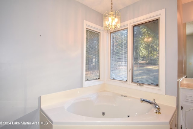 bathroom with a chandelier, vanity, plenty of natural light, and a washtub