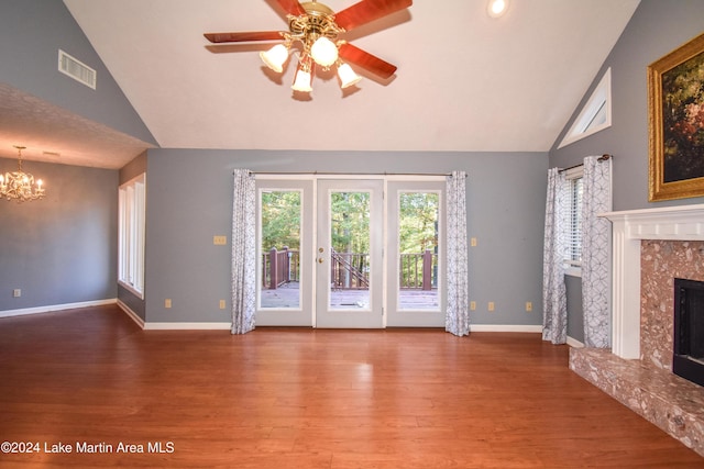 unfurnished living room with a high end fireplace, wood-type flooring, ceiling fan with notable chandelier, and high vaulted ceiling