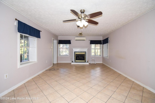 unfurnished living room with ceiling fan, a wall unit AC, a textured ceiling, light tile patterned floors, and ornamental molding