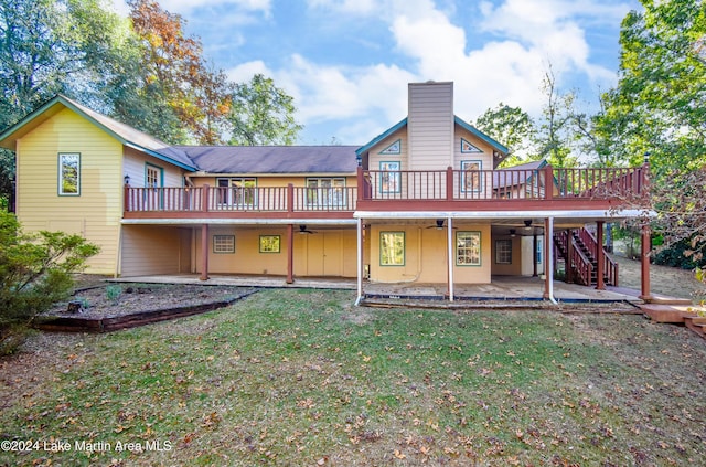 back of property with a lawn, a patio area, and a deck