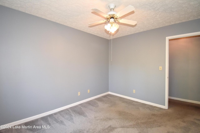 empty room with carpet, ceiling fan, and a textured ceiling