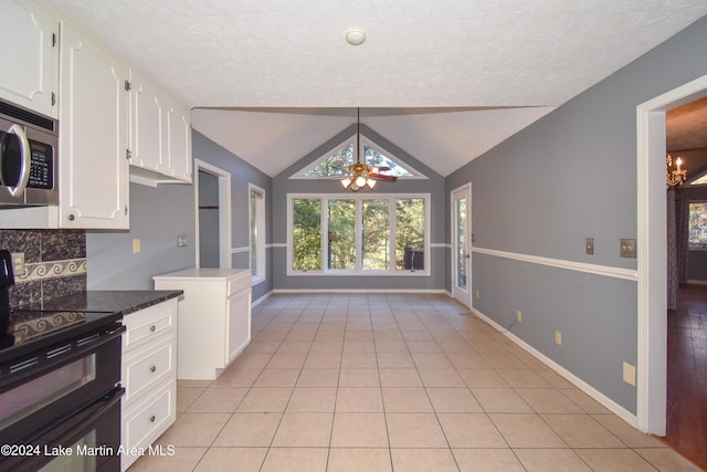 kitchen with vaulted ceiling, electric range, ceiling fan, light tile patterned floors, and white cabinetry