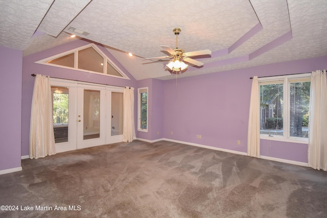 carpeted spare room with french doors, a textured ceiling, ceiling fan, and a healthy amount of sunlight