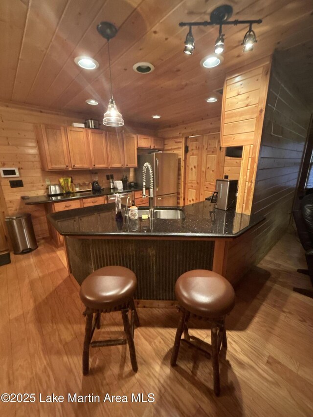 151 Pemberton Rd, Tallassee, AL 36078 - kitchen featuring light wood-style floors, wood ceiling, a sink, freestanding refrigerator, and wooden walls