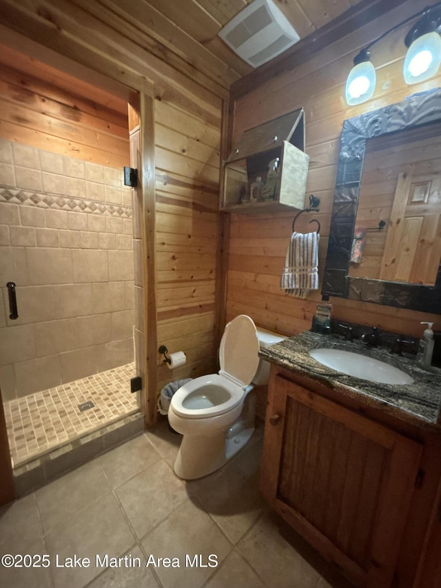 151 Pemberton Rd, Tallassee, AL 36078 - bathroom featuring a stall shower, toilet, wooden walls, vanity, and tile patterned floors
