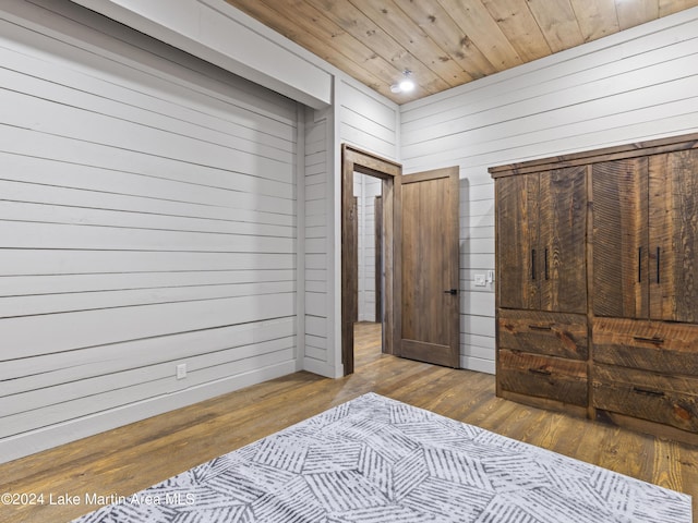 bedroom with wood walls, wood-type flooring, and wood ceiling