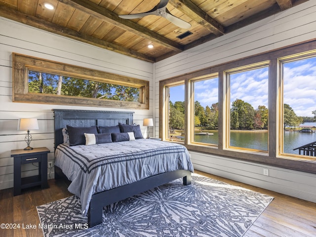 bedroom with hardwood / wood-style flooring, wood walls, a water view, and wood ceiling