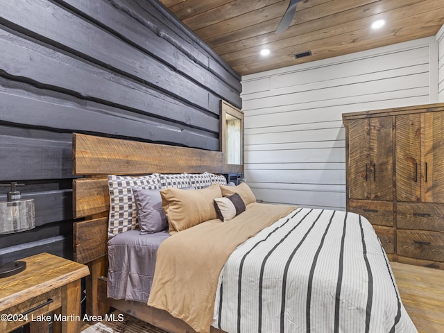 bedroom featuring hardwood / wood-style flooring, wood ceiling, and wood walls