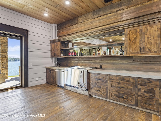 kitchen featuring a water view, wooden ceiling, dark wood-type flooring, and wooden walls