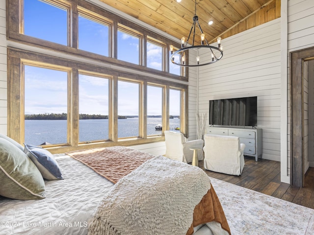 bedroom with wooden ceiling, dark wood-type flooring, high vaulted ceiling, a water view, and wooden walls