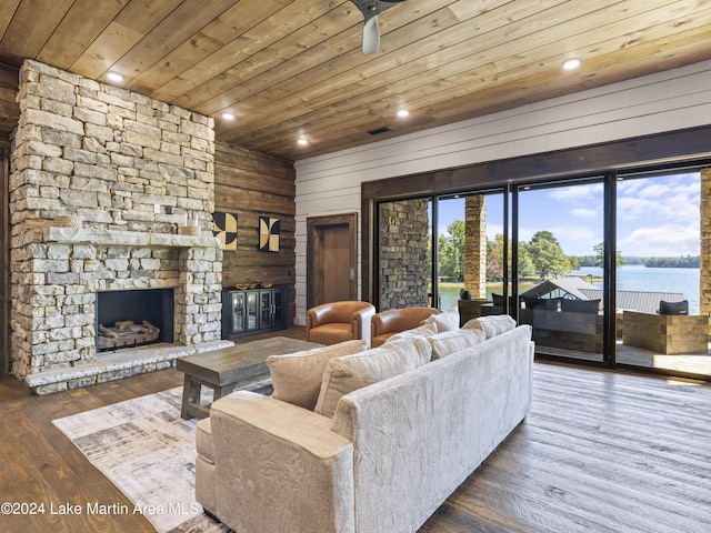 living room featuring wooden ceiling, a water view, wooden walls, a fireplace, and dark hardwood / wood-style flooring