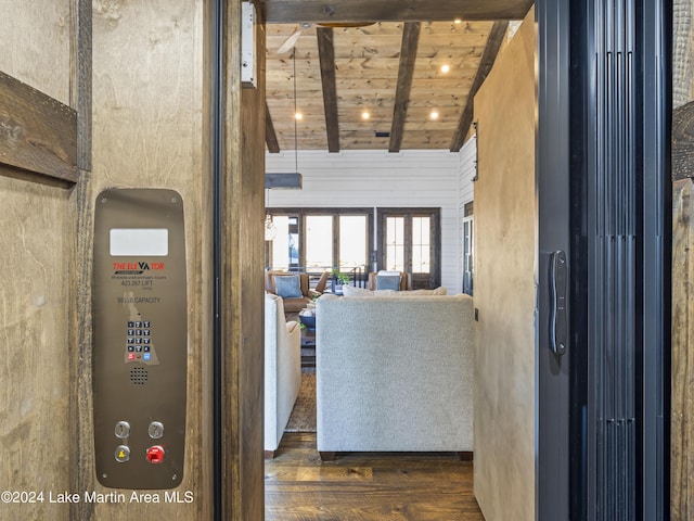 interior space with wooden ceiling, french doors, lofted ceiling with beams, wooden walls, and dark hardwood / wood-style floors