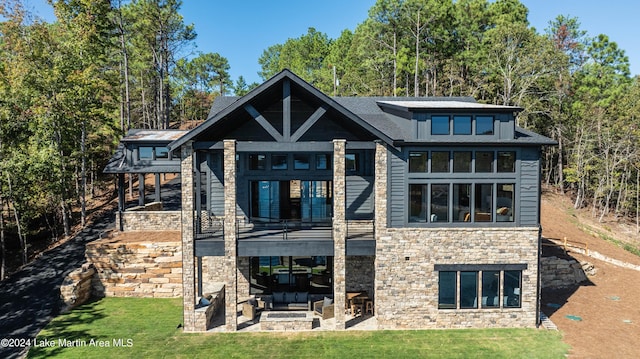 back of house with a lawn, a patio area, a balcony, and an outdoor hangout area