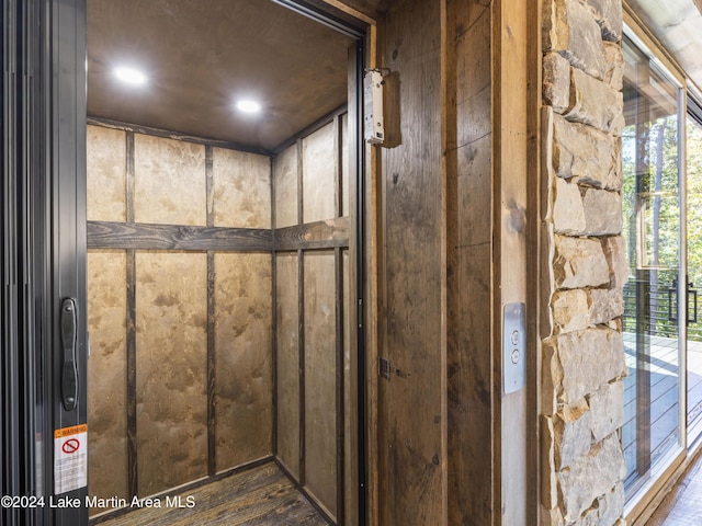 interior details featuring hardwood / wood-style flooring and elevator