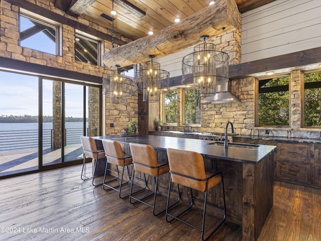 bar with a healthy amount of sunlight, a water view, and high vaulted ceiling