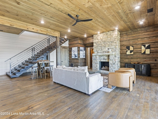 unfurnished living room featuring ceiling fan, dark hardwood / wood-style flooring, wood walls, a fireplace, and wood ceiling