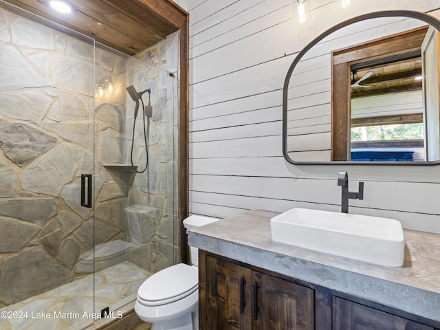 bathroom featuring toilet, wood walls, an enclosed shower, and vanity