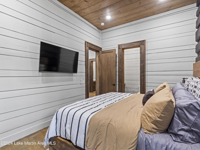 bedroom with wood ceiling, wood walls, and dark wood-type flooring