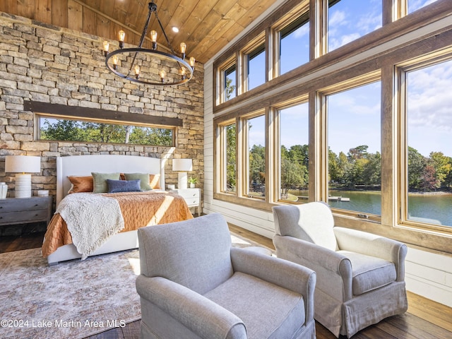 bedroom with wooden ceiling, high vaulted ceiling, a notable chandelier, hardwood / wood-style floors, and a water view