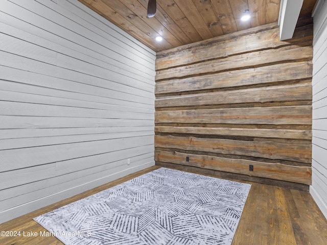 interior space with wood walls, wood-type flooring, and wooden ceiling