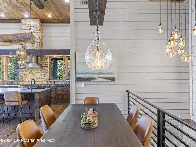 dining room with a wealth of natural light, wooden walls, and dark hardwood / wood-style floors