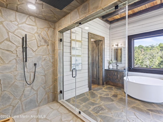 bathroom with beamed ceiling, vanity, shower with separate bathtub, and wooden walls