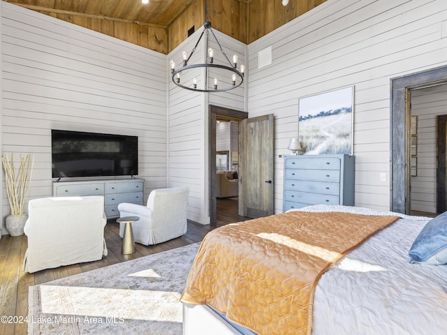 bedroom with high vaulted ceiling, a notable chandelier, dark wood-type flooring, and wood walls