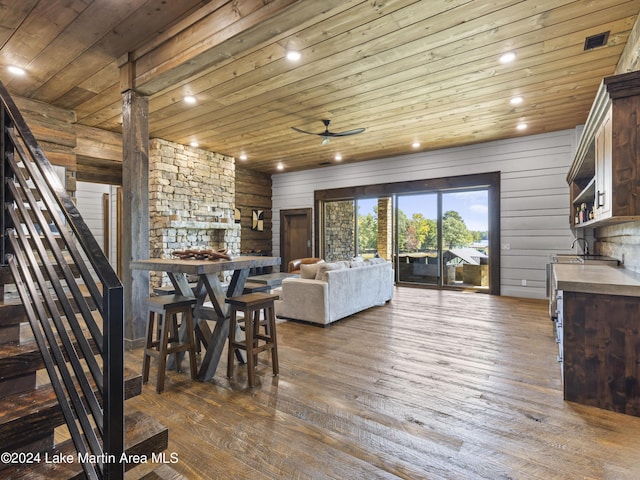 dining room featuring dark hardwood / wood-style flooring, ceiling fan, wooden ceiling, and wood walls