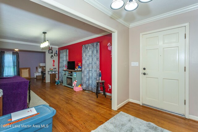 entryway with hardwood / wood-style flooring and ornamental molding