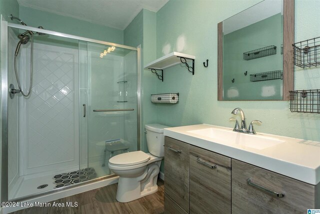 bathroom with walk in shower, toilet, vanity, and hardwood / wood-style flooring