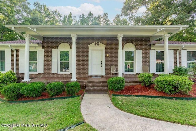 view of front of home with covered porch and a front yard