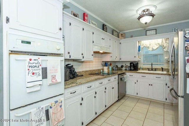 kitchen with white cabinets, crown molding, sink, appliances with stainless steel finishes, and light stone counters